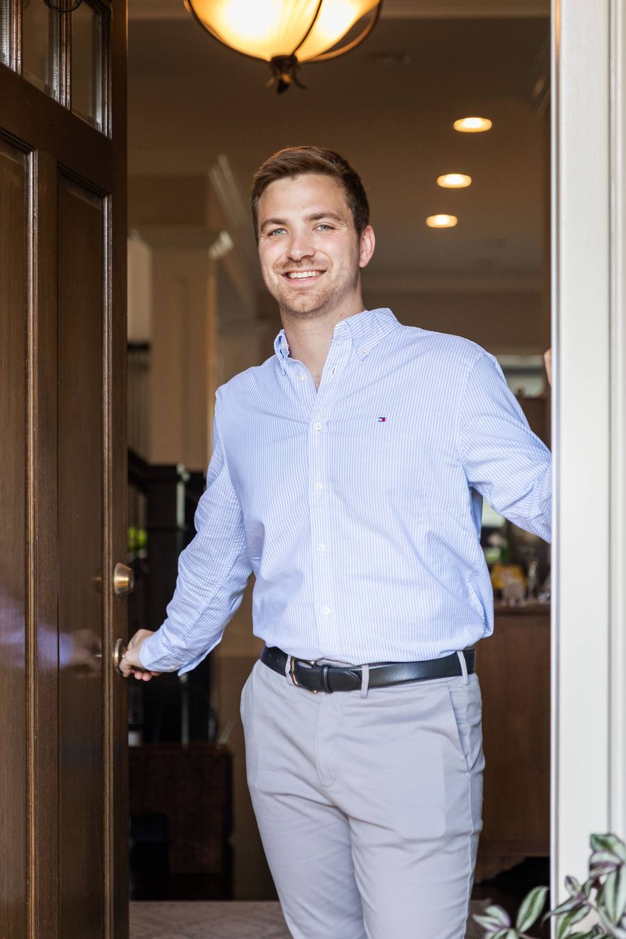 Connor Heriot opening the front door of a home for buyers