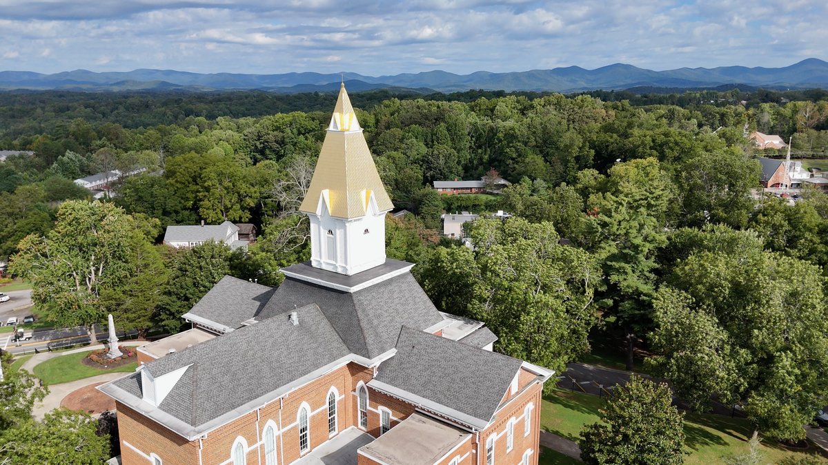 Price Memorial Hall at the University of North Georgia in Dahlonega, its steeple covered in Dahlonega gold, with the Blue Ridge mountains behind